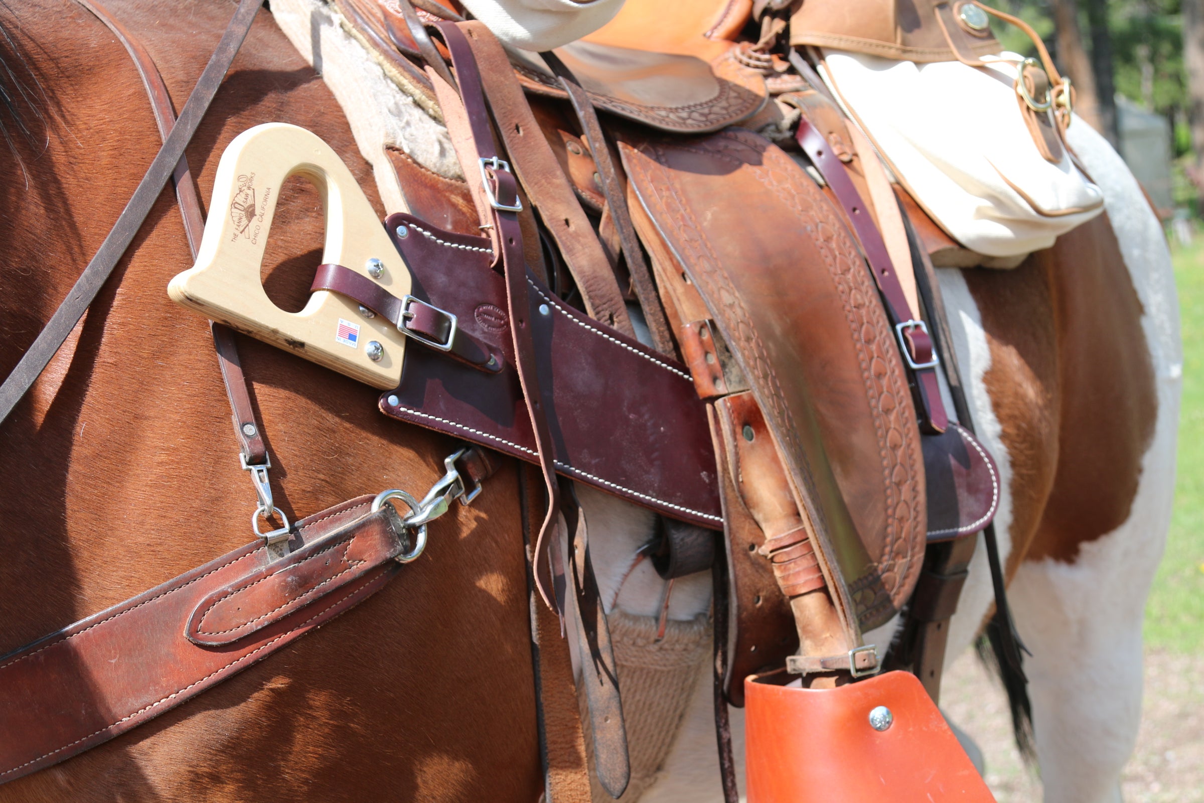 A Fanno saw with handmade leather scabbard pictured, secured to a riding saddle for a camping trip or long trail ride